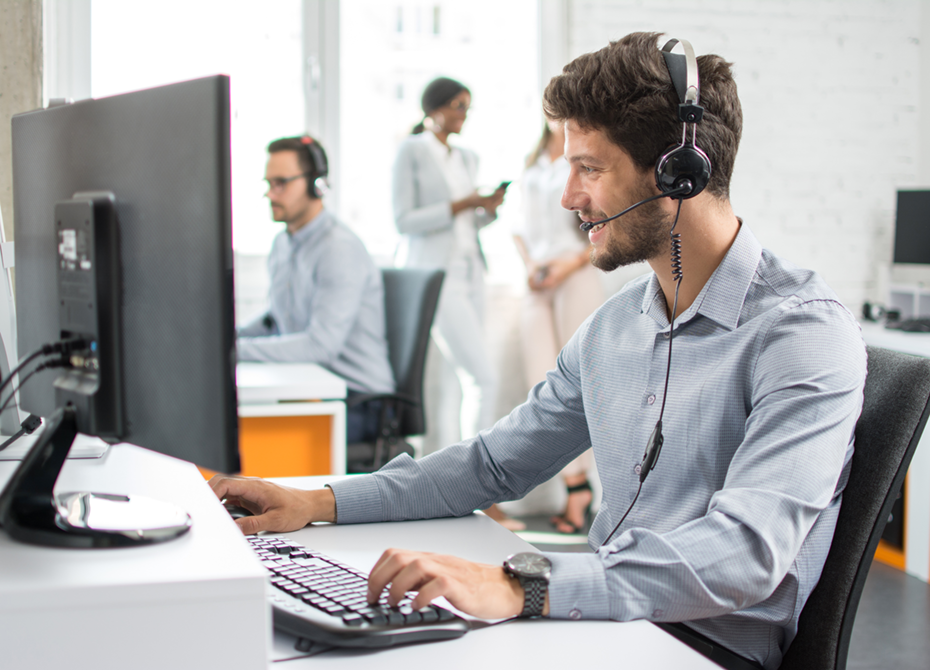 Customer support team member wearing a headset, assisting with inquiries related to regulatory compliance and operational standards in a modern office environment.