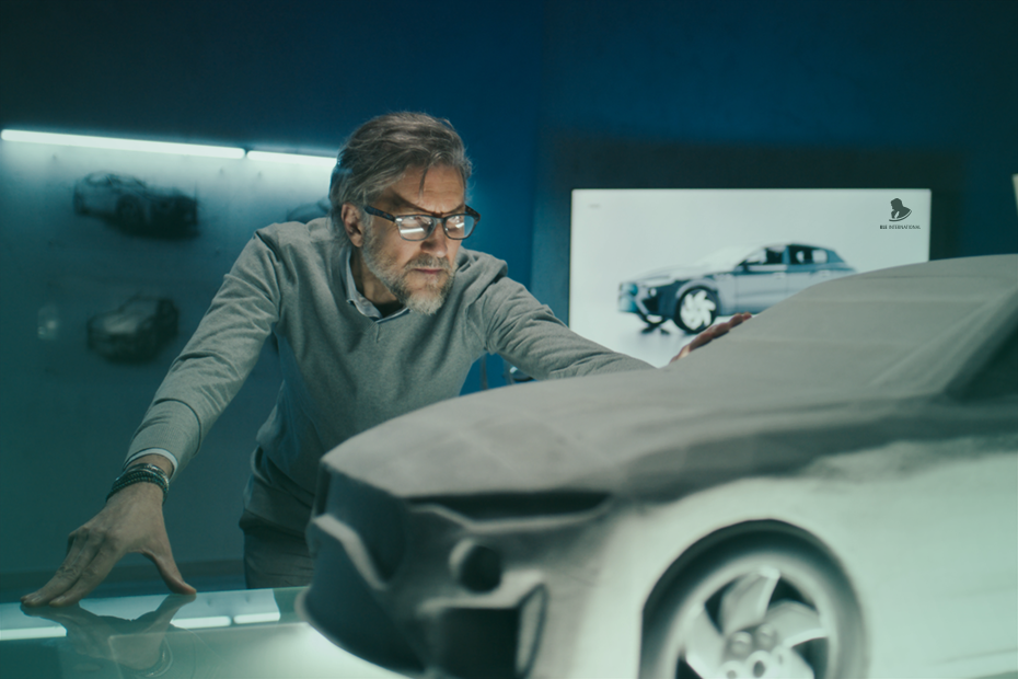 A designer examines a car model during the prototyping phase, showcasing advanced services in vehicle development within a design studio.