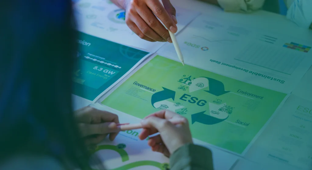 Hands review ESG documents focusing on governance, environment, and social topics as part of sustainability initiatives and clean energy goals.