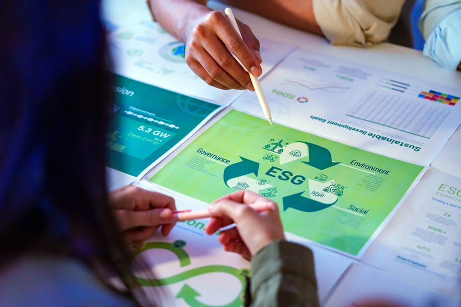 A group discusses ESG (Environmental, Social, Governance) strategies using detailed documents and charts, with a focus on Governance as part of sustainable development goals and clean energy initiatives.