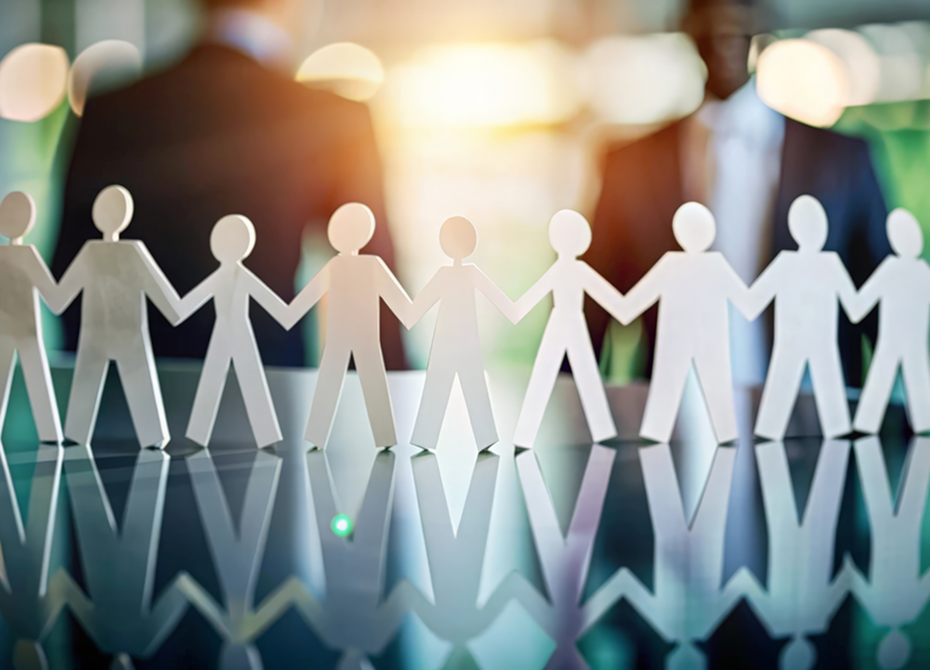 A row of paper cutout figures holding hands reflects teamwork and collaboration, with a professional business setting in the background, aligning with the company's commitment to social responsibility.