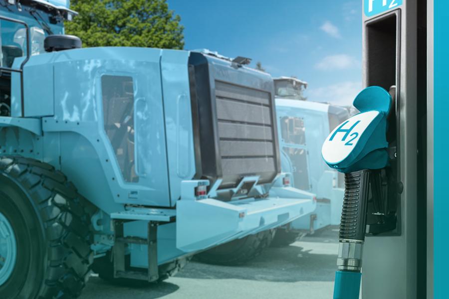 A close-up view of a hydrogen fueling station nozzle alongside heavy machinery equipped with hydrogen technology, showcasing advancements in sustainable industrial energy solutions.